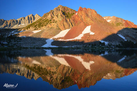 Sunset reflection in an alpine lake in the Sierra Nevada in California.