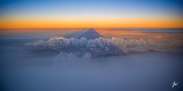 Rare sunrise photograph from the summit of Mount Everest (29,032'), revealing Everest's shadow over the Earth.