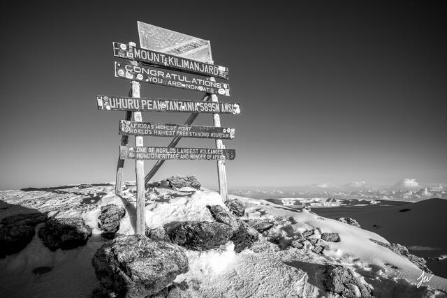 Summit sign in black and white at Mount Kilimanjaro photographed near Uhuru Peak, the highest point in Africa. 