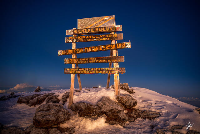 Summit sign at Mount Kilimanjaro photographed at dawn near Uhuru Peak, the highest point in Africa.