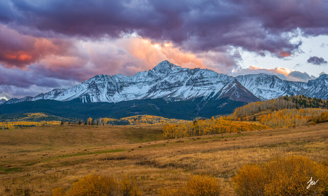 Wilson Peak at sunset in Telluride, Colorado, with vibrant fall colors and golden aspens in the foreground.