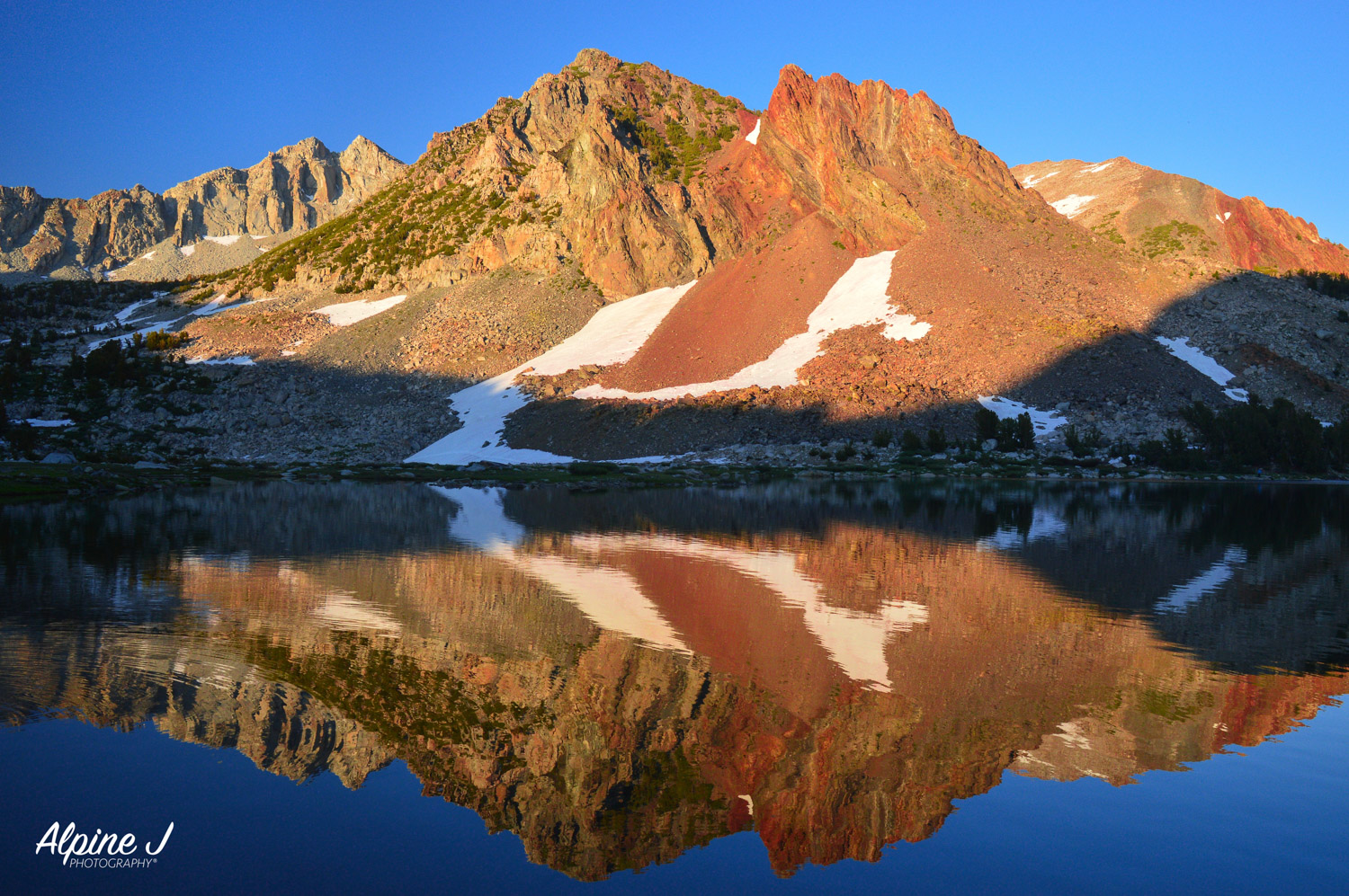 Sunset reflection in an alpine lake in the Sierra Nevada in California.