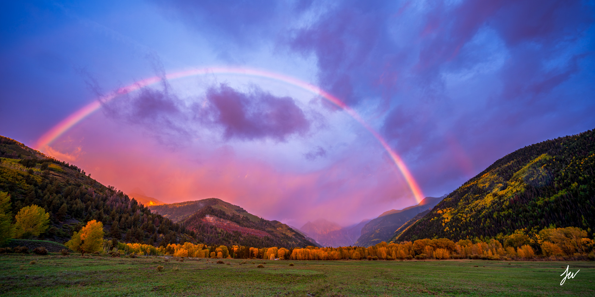 Awestruck Rainbow over Telluride, Colorado, with golden autumn trees and dramatic storm clouds in the San Juan Mountains.